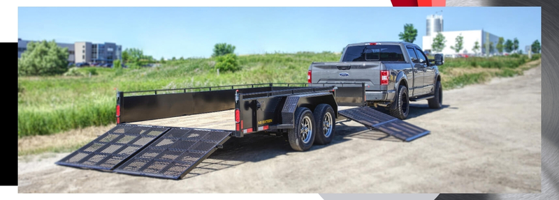 One Sixteen tandem axle utility trailer attached to a Ford pickup truck with loading ramps extended, ideal for heavy-duty hauling in Ontario – McFarlane Trailer Sales