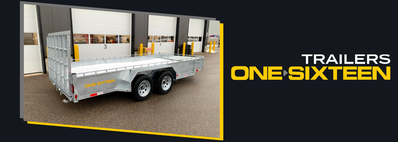 Silver dual-axle utility trailer parked outside a warehouse, with ONE SIXTEEN branding on the side.