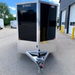 image2 51 - McFarlane Trailer Sales Black enclosed cargo trailer with aluminum framing and diamond-plate trim, hitched in an industrial lot.
