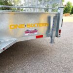 Metal trailer side with yellow 'ONE SIXTEEN' branding and a dealership sticker, outdoors in a parking lot.