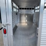 image5 42 - McFarlane Trailer Sales Empty aluminum livestock trailer interior with side stalls and ribbed floor along the length of the trailer door opening