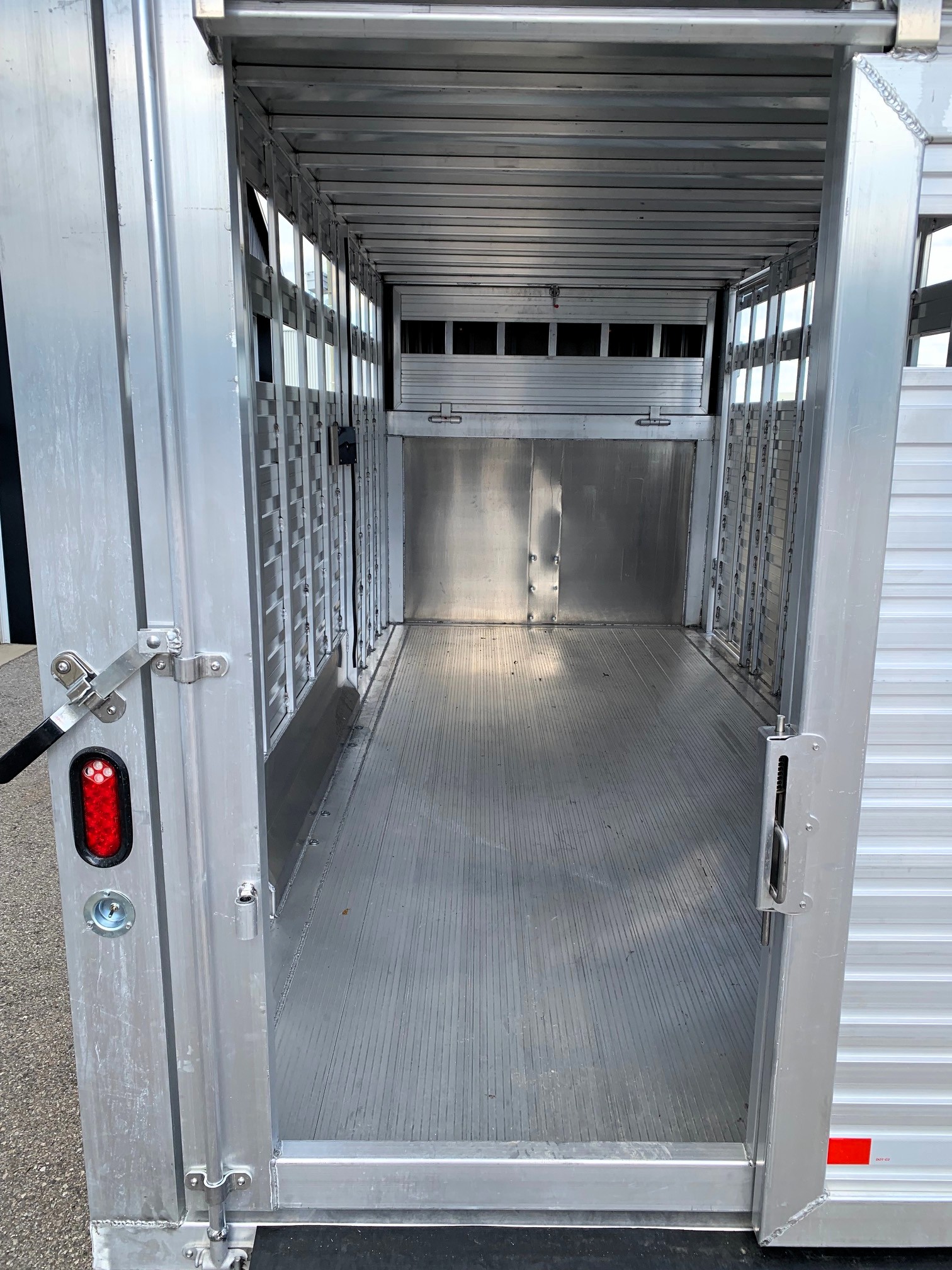 image5 42 - McFarlane Trailer Sales Empty aluminum livestock trailer interior with side stalls and ribbed floor along the length of the trailer door opening