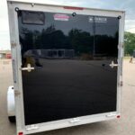 image4 51 - McFarlane Trailer Sales Rear view of a black enclosed trailer with silver aluminum frame and two doors, displaying ENBECK Aluminum Products logo sticker.