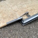 image6 33 - McFarlane Trailer Sales Sheet of OSB plywood resting on a metal trailer bed with support brackets visible at the edge.