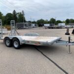 image1 68 - McFarlane Trailer Sales Row of gray cargo trailers parked in a lot under a cloudy sky, stretching into the distance.